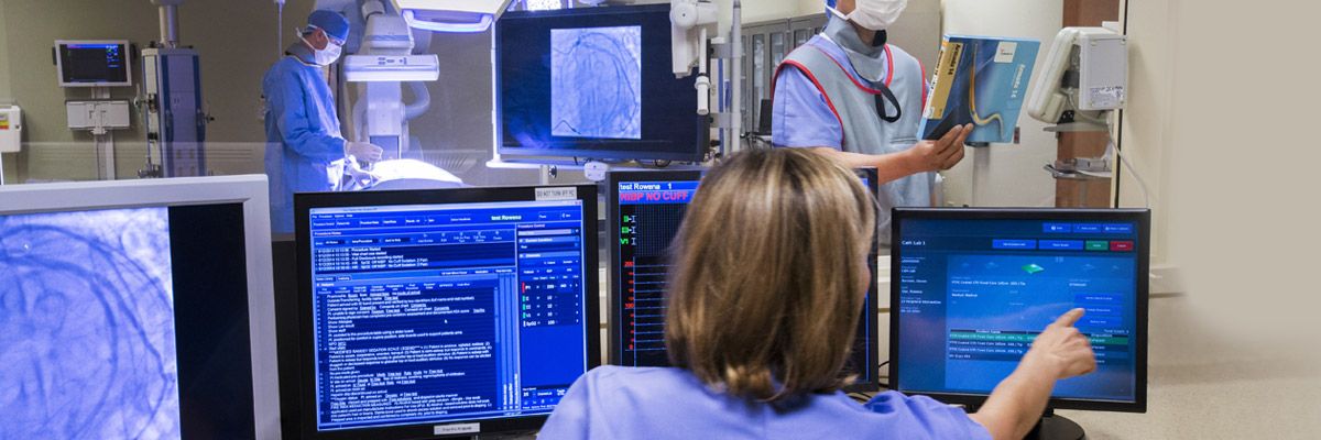 Medical professional looking at multiple computer screens.