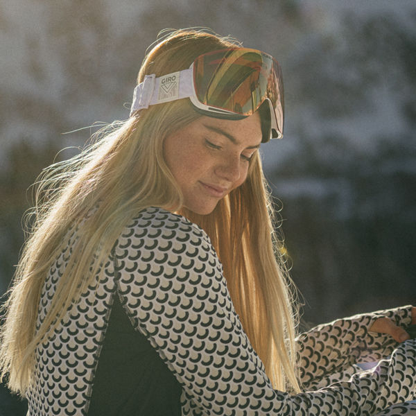 Female Snowboarder on a mountain wearing baselayer and goggles