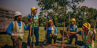 Students pose while planting a tree