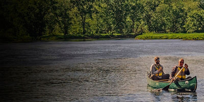 A park ranger and Secretary Ryan Zinke paddle down the river in a canoe in Katahdin Woods and Waters National Monument