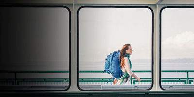 A woman walks on a ferry with her travel pack