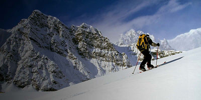 A man backcountry ski touring up a mountain