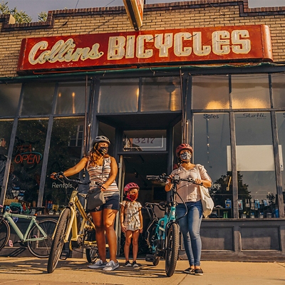 Three women standing outside a bike shop