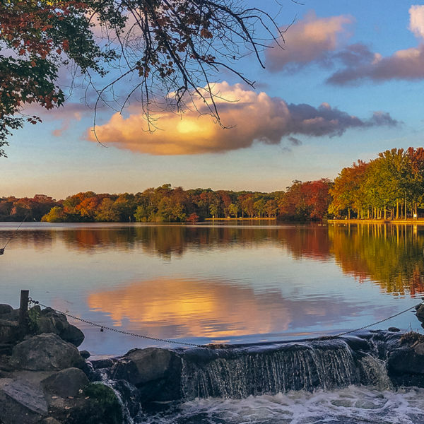 A man fishing next to a waterfall on Long Island, New York