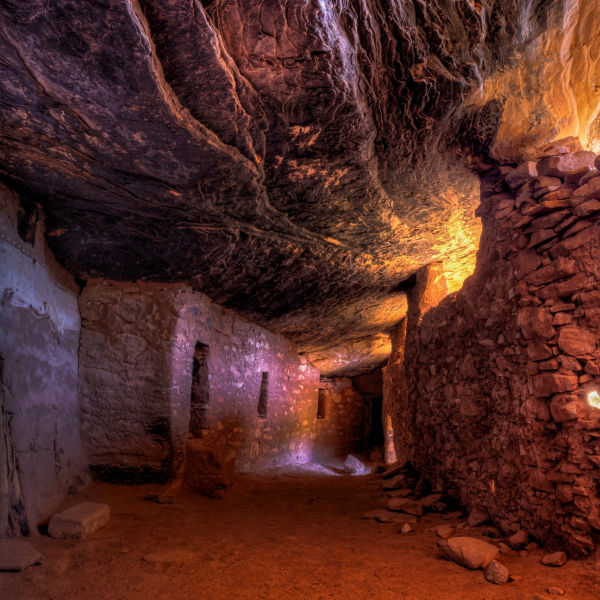 Indirect bounce light creates colors in an ancient interior hallway below a sloping layered cliff wall in the late 13th century Moon House in McCloyd Canyon, Bears Ears National Monument.