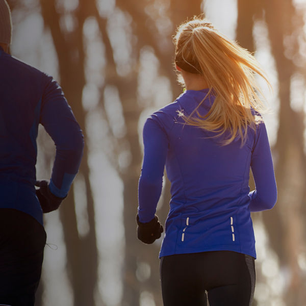 The backs of two runners on a winter path