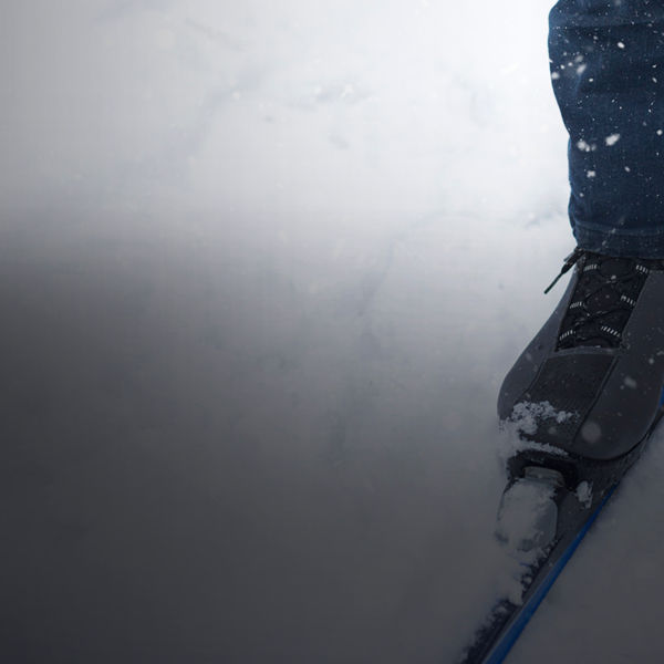 Feet of a skier in ski boots on cross-country skis. Walking in the snow, winter sports, healthy lifestyle. Close-up, copyspace