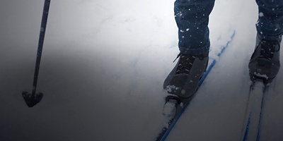 Feet of a skier in ski boots on cross-country skis. Walking in the snow, winter sports, healthy lifestyle. Close-up, copyspace