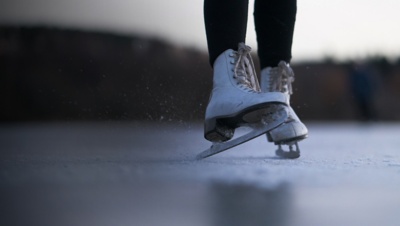 A detail of an ice skater on a pond