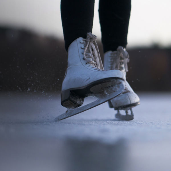 A detail of an ice skater on a pond