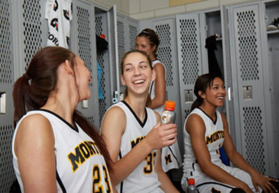 Women basketball players laughing in the locker room.