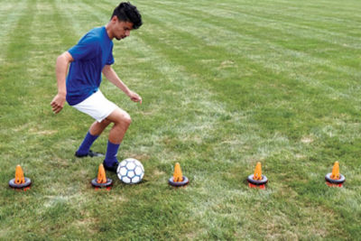 soccer player practicing with cones and soccer ball