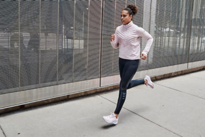 Woman running down sidewalk in running gear