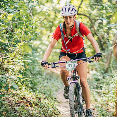 A woman bikes in a race on the Chestnut Ridge Mountain bike trail