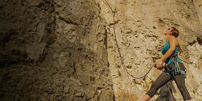 A woman belays a lead climber