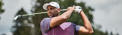 A man fallowing his ball after hitting it with an iron.