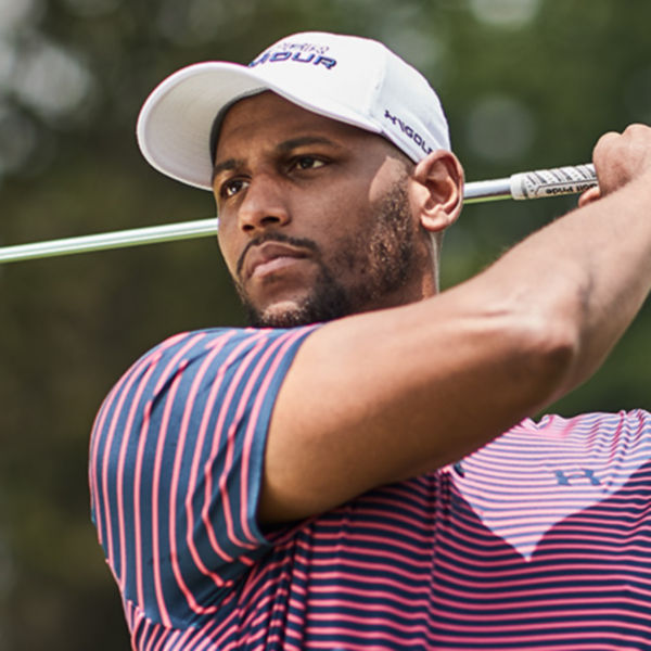 A man fallowing his ball after hitting it with an iron.