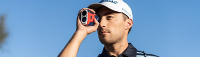 A man with a range finder up to his eye.