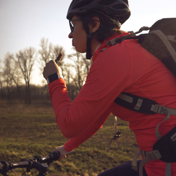 Woman eats protein bar ride on mountain bike in nature. 