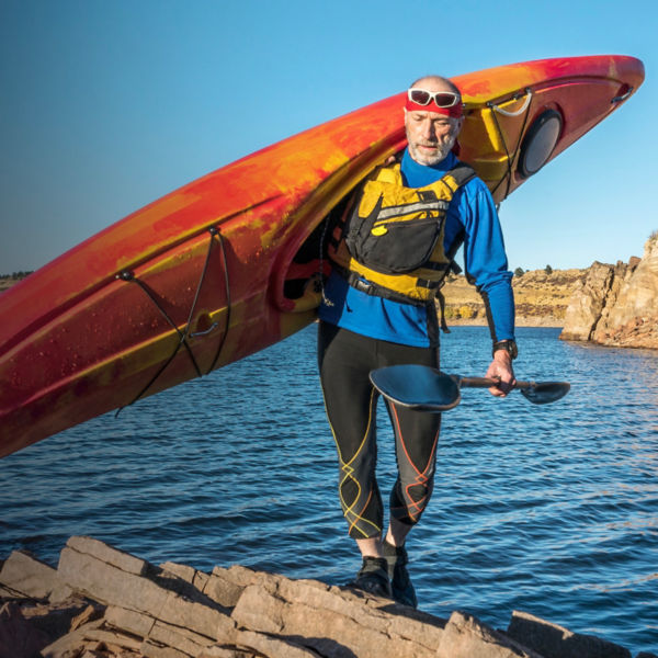 carrying river kayak on lake shore
