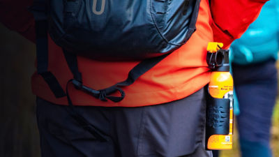 Bear spray self-defence attached to backpackers when hiking 