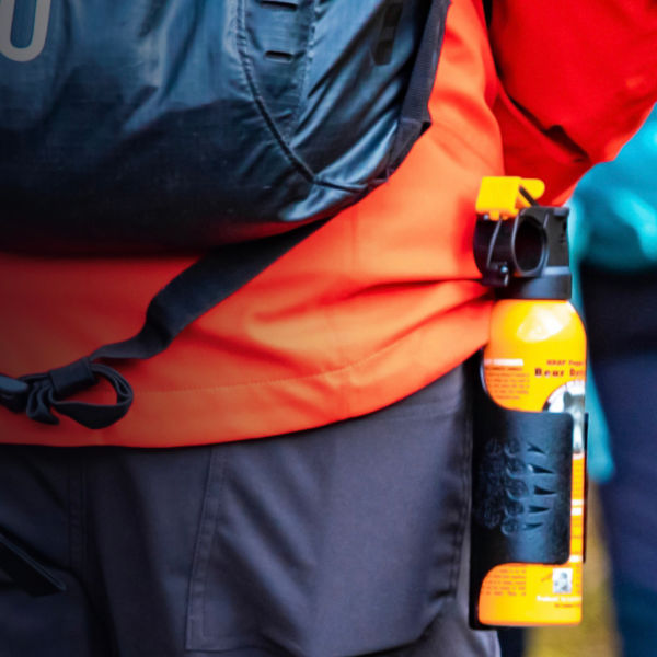 Bear spray self-defence attached to backpackers when hiking 