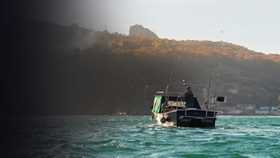 Fishing speedboat with angling man at foggy bay