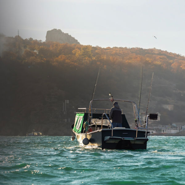 Fishing speedboat with angling man at foggy bay