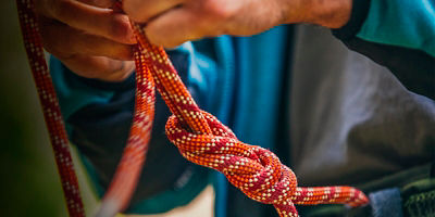 A man ties a Figure 8 knot and backup Fisherman's knot before climbing
