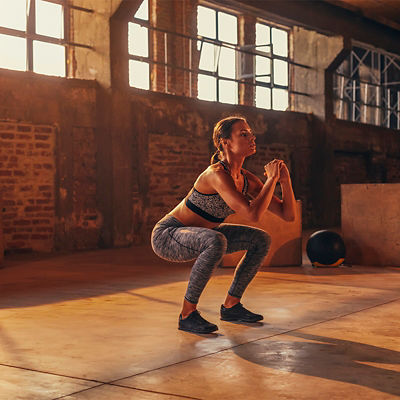 A woman does an air squat in a gym