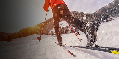 Man cross-country skiing during sunny winter day.