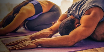 A man and woman doing yoga at home