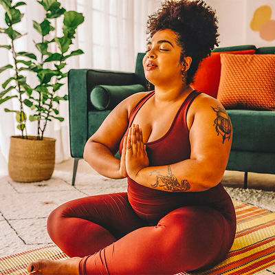 A woman practicing relaxation yoga at home