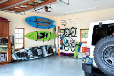 Kayak and paddle board in a garage. 