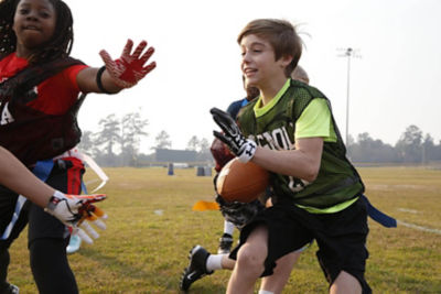 Kids playing flag football on the football field.