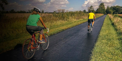 A man and a woman ride their bike along the Ohio to Erie trail