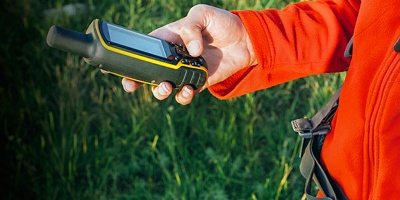 Close up of hiker young woman holding in her hand GPS navigator, Global Positioning System device. 