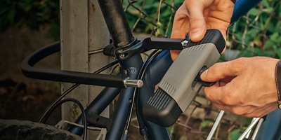 A person locks a bike with a U-lock