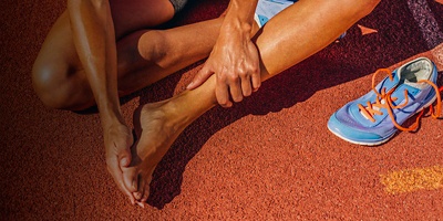 A woman rubs her feet after a run