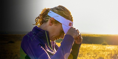 A woman adjusts her visor during a run at sunrise on the trails of Green Mountain near Denver, Colorado.