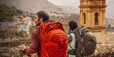 A man and a woman trek through the medieval streets of Chulilla, Spain.