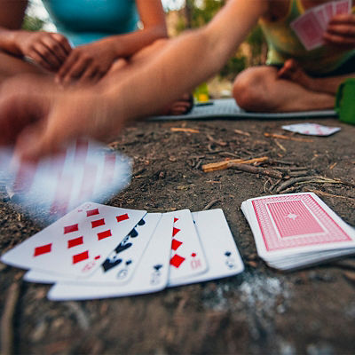 Two women play cards and enjoy a fire while car camping along the Salmon River near Stanley. Idaho.