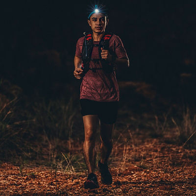 Trail runner running on the rocky road in the night
