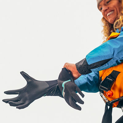 Closeup of a female kayaker with a drysuit and full boating gear putting on gloves at the Three River Motel along the Lochsa River in Idaho.