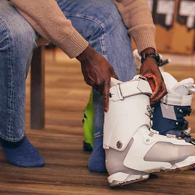 A man putting on a ski boot