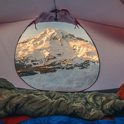 A snowy sunset on Mount Rainier as seen through a tent door.