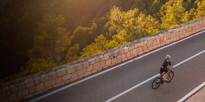 A woman rides her bike uphill