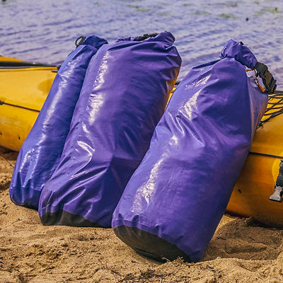 Dry bags sit next to a kayak