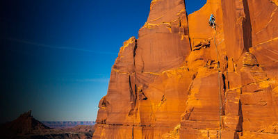 A climber on the popular South Face (5.7) tradroute on South Sixshooter tower in Utah's Indian Creek.