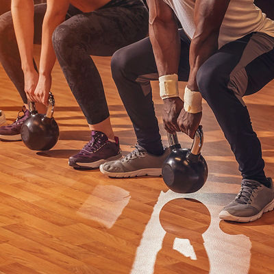 People using kettlebells in squats 
